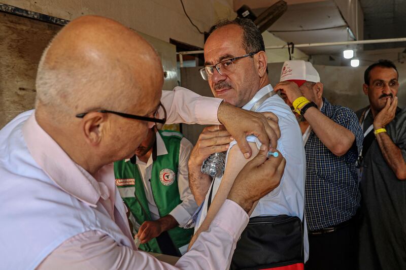 A Palestinian Muslim pilgrim receives a Covid-19 vaccine dose at the Rafah border crossing with Egypt as they head to Saudi Arabia for the annual Hajj pilgrimage. AFP