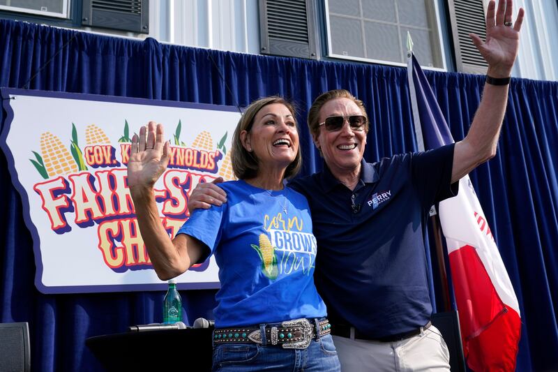 Republican presidential candidate and author Perry Johnson waves with Ms Reynolds at the fair. AP
