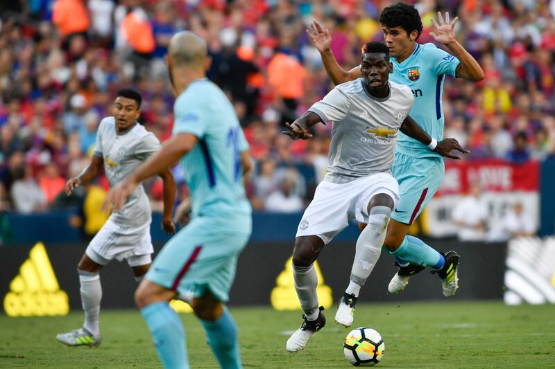 Manchester United's Paul Pogba dribbles through Barcelona defenders. Larry French / AP Photo