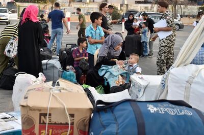 epa07026639 Syrian refugees gather as they prepare to leave Beirut, before their journey to their homes in Syria at the Sport City in Beirut, Lebanon, 17 September 2018. Around 200 Syrian refugees began their trip home as part of a coordinated operation between authorities in Beirut and Damascus.  EPA/WAEL HAMZEH