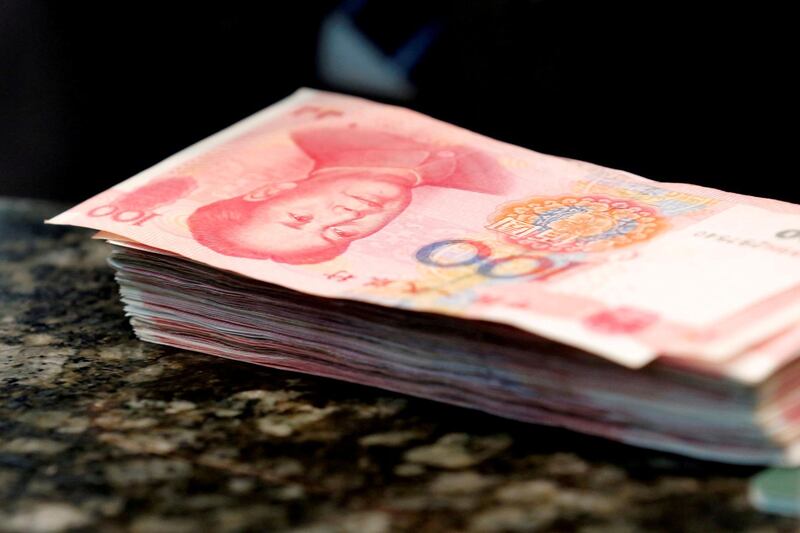 FILE PHOTO: Chinese 100 yuan banknotes are seen on a counter of a branch of a commercial bank in Beijing, China, March 30, 2016. REUTERS/Kim Kyung-Hoon/File Photo