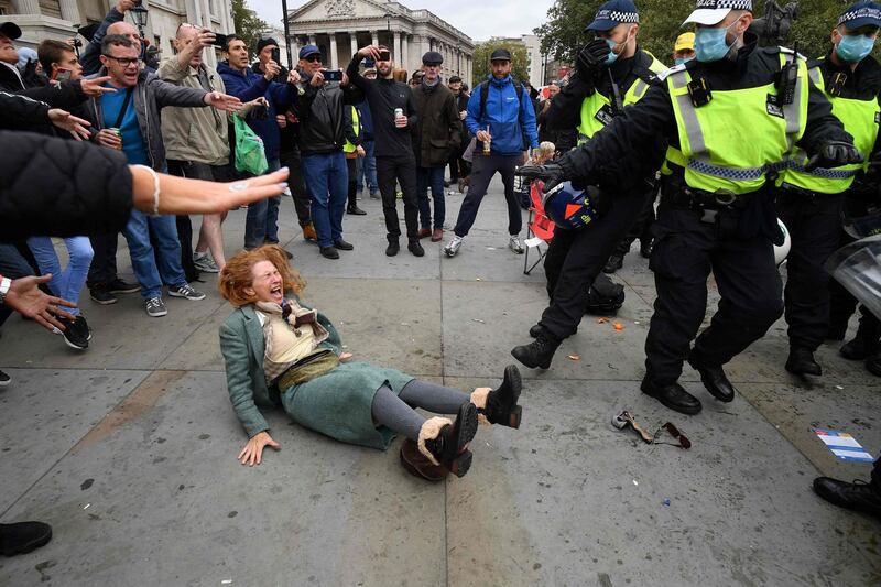 A woman gestures after falling as police move in to disperse protesters in Trafalgar Square. AFP