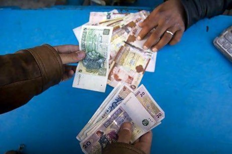 A customer changes Tunisian dinars for Libyan currency in Ben Garden. Lindsay Mackenzie.