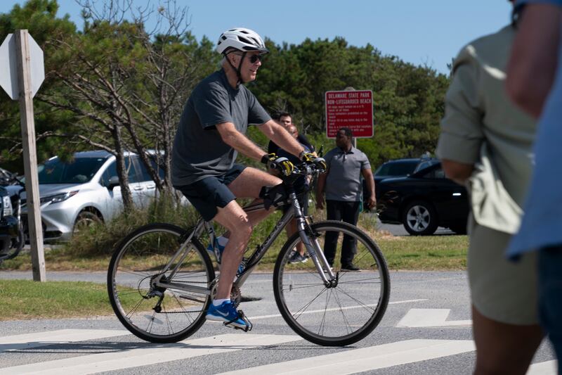 Mr Biden pedalled his bike towards a crowd where people were eager to meet the president. Reuters