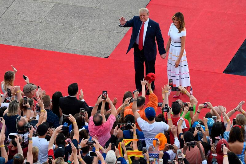 US President Donald Trump and First Lady Melania Trump wave to the crowd as they arrive to the "Salute to America" Fourth of July event at the Lincoln Memorial in Washington. / AFP / POOL / Susan Walsh