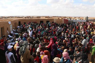 epa07142941 A handout photo made available by Syrian Arabic Red Crescent (SARC) showing displaced Syrians gather as SARC personnel conduct a vaccination campaign to immunize children against measles, polio and hepatitis at al-Rukban Camp near the Jordanian border, south-east Syria, 05 November 2018. According to the UN, an operation to deliver humanitarian assistance to 50,000 people in need at Rukban camp in south-east Syria started on 04 November and is expected to take up to four days, the first of kind since the last UN delivery in January 2018, delivered through Jordan.  EPA/SARC HANDOUT  HANDOUT EDITORIAL USE ONLY/NO SALES