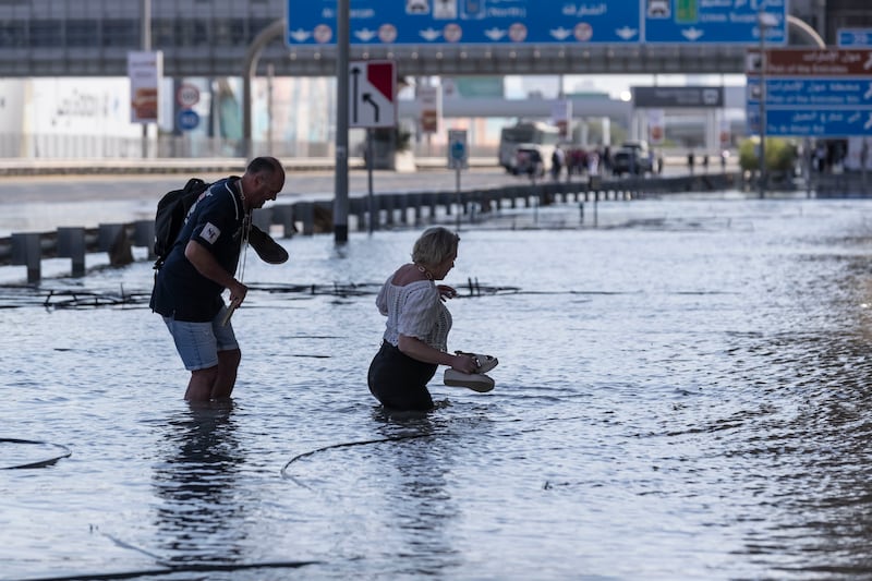 People attempt to navigate the floodwaters in Dubai. 
Antonie Robertson/The National