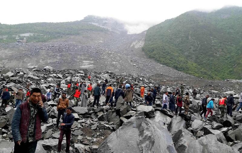 Chinese police, soldiers, rescue workers and civilians search through the site of a landslide in Xinmo village, Sichuan province, on June 24, 2017. AFP 