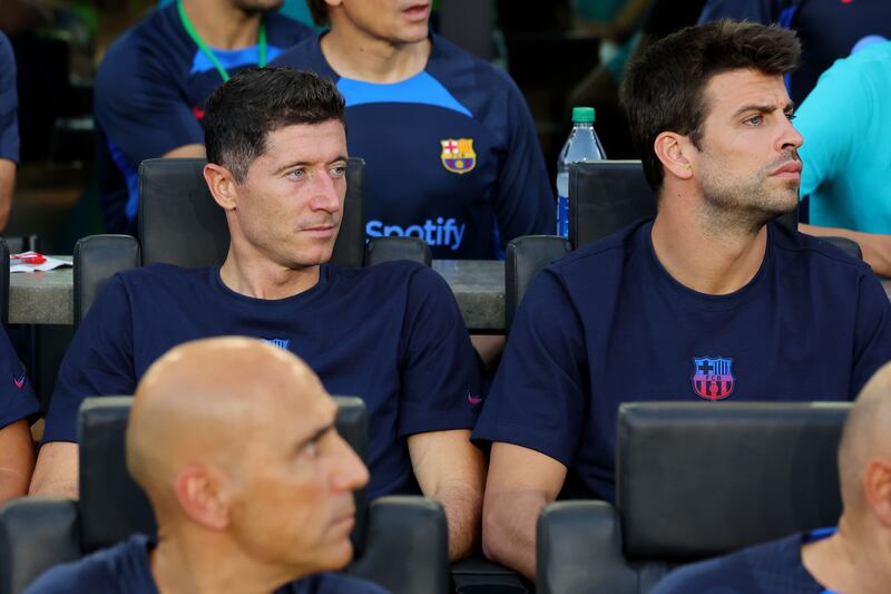 Robert Lewandowski and Gerard Pique of Barcelona look on from the bench during the friendly against Inter Miami. AFP