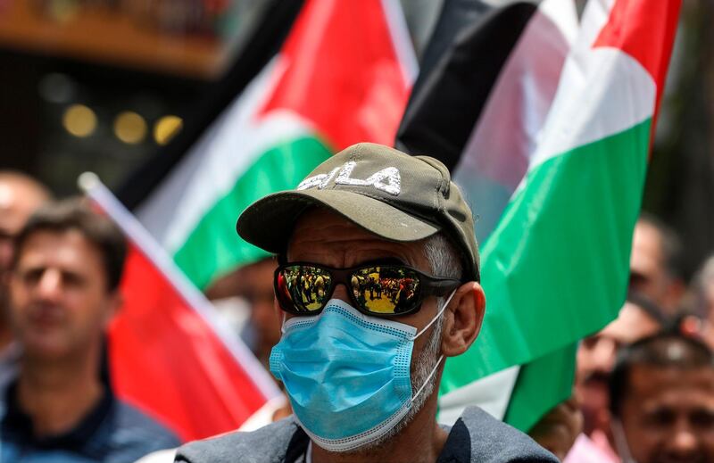 A demonstrator clad in sunglasses and mask looks on during a protest against Israeli plans to annex parts of the occupied West Bank, in the West Bank city of Nablus.  AFP