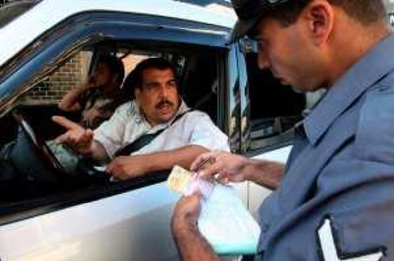 A Lebanese driver argues with a traffic policeman as he issues the former a driving infraction ticket in Beirut on October 13, 2008. Something of a revolution is taking place on Lebanon's notoriously dangerous roads. Drivers are beginning to stop at red lights, to wear seat belts and no longer have their cell phones glued to their ears. All thanks to a crackdown ordered by the country's new no-holds-barred Interior Minister Ziad Baroud who has unleashed a small army of traffic cops to impose law and order in a country where rules appear made to be broken. AFP PHOTO/RAMZI HAIDAR
