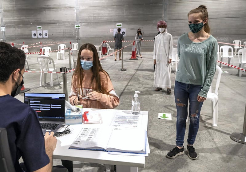 Abu Dhabi, United Arab Emirates, March 18, 2021.  Students, Imogen-18 and Georgia-16,(left), both from Cranleigh School, Abu Dhabi wait in line to get tested at the Biogenix lab at G42 in Masdar City.
Victor Besa/The National
Section:  NA
Reporter:  Shireena Al Nowais