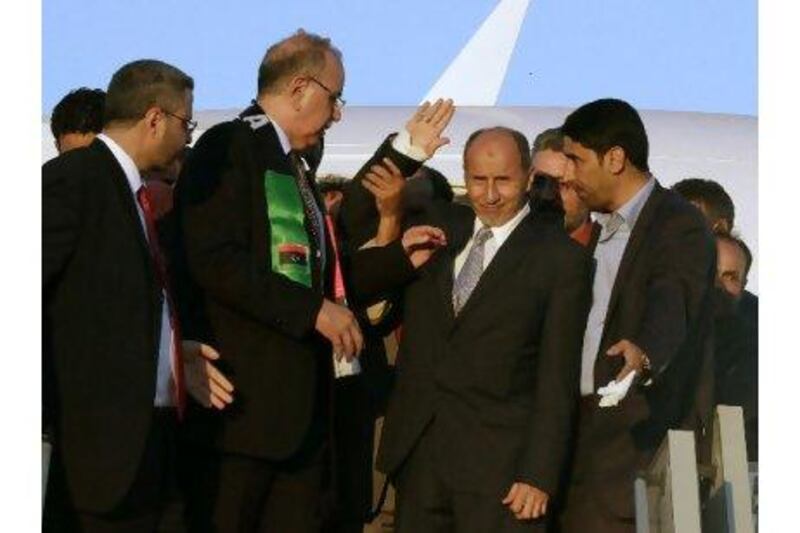 The head of the National Transitional Council, Mustafa Abdul Jalil, centre, waves upon his arrival at Mitiga airport in Tripoli. Anis Mili / Reuters