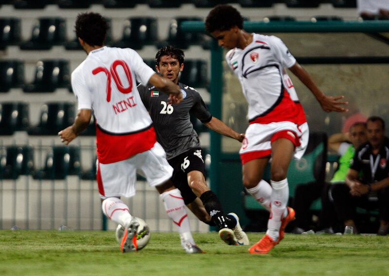 Dubai, United Arab Emirates, Sept. 9 2012,  Emirates vs Al Dhafra-  (centre dark kit) Al Dhafra's 26 attempts to work the ball past  (left) Emirates "70 NiNi  in first half action. Mike Young / The National 