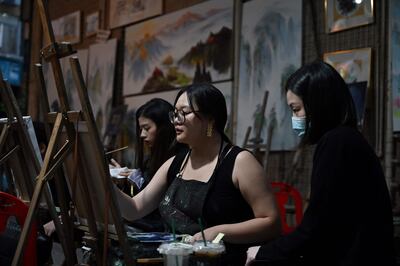 People practise painting in an alley in Dafen Village