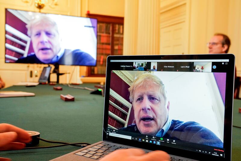 Boris Johnson appears on monitors for a meeting in London. The prime minister chaired the morning update meeting remotely as he was self-isolating after testing positive for 
Covid-19. Reuters
