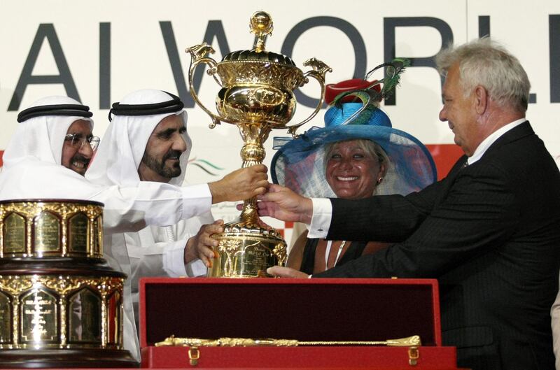 Emirati Finance Minister Sheikh Hamdan bin Rashed al-Maktoum (L) and Dubai ruler Sheikh Mohammed bin Rashed al-Maktoum (2nd-L) give the trophy to Brazilian Stefan Friborg (R) and his wife Dalva de Oliveira, owners of Gloria De Campeao which won the Dubai World Cup, at the Meydan race track in the Gulf emirate on March 27, 2010. French runner Gloria De Campeao won the world's richest race, the 10-million-dollar Dubai World Cup. AFP PHOTO/MARWAN NAAAMANI (Photo by MARWAN NAAMANI / AFP)