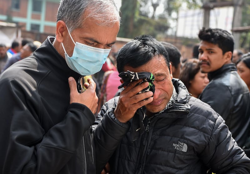 Family members of a plane crash victim react outside a morgue at the Teaching Hospital in Kathmandu on March 13, 2018, a day after the deadly crash of a US-Bangla Airlines plane at the international airport. Prakash Mathema / AFP
