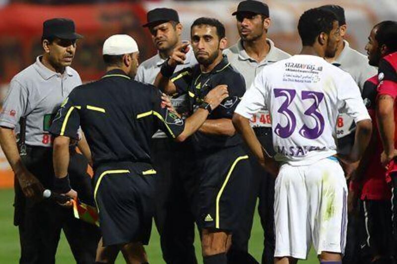 Mohamed Al Mehairi, second left, was hit by a missile thrown from the Al Ahli supporters' section at the Rashid Stadium.