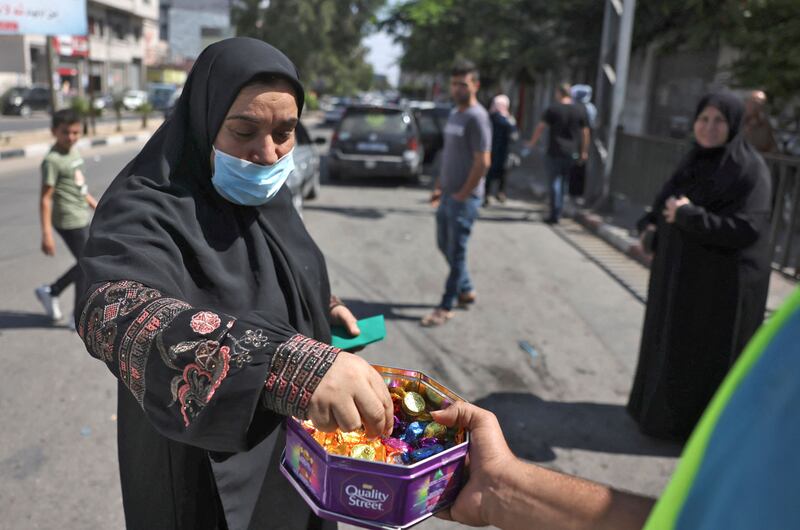 A Palestinian man distributes sweets to celebrate the escape of six Palestinians from an Israeli prison, in Gaza Strip.  - Six Palestinians broke out of an Israeli prison through a tunnel dug beneath a sink, triggering a massive manhunt for the group that includes a prominent ex-militant.  AFP