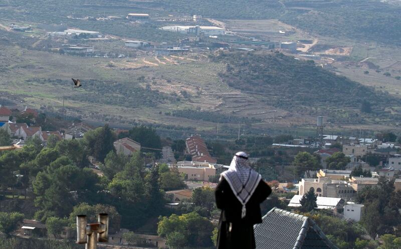 (FILES) In this file photo taken on November 23, 2020 a Palestinian man looks towards the Israeli settlement of Shavei Shomron built next to the Palestinian village of Naqoura, west of Nablus in the occupied West Bank. Israel's prime minister on January 11, 2021 directed authorities to approve construction of 800 new homes for Jewish settlers in the occupied West Bank days before President Donald Trump's pro-Israel administration leaves office. / AFP / JAAFAR ASHTIYEH
