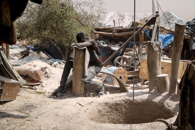 A worker rests his head on a wooden stump at a gold mine in Bouda, Burkina Faso. AP Photo