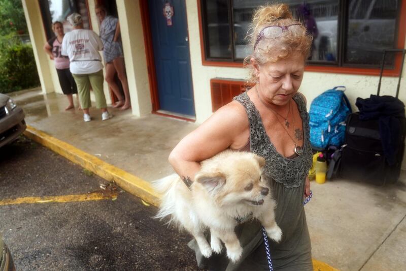 Lenora Adams loads up her dog as she evacuates a motel as Hurricane Michael comes ashore in Panacea, Florida. Reuters
