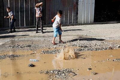 Palestinian children play by a puddle in the Israeli-occupied West Bank. Reuters 