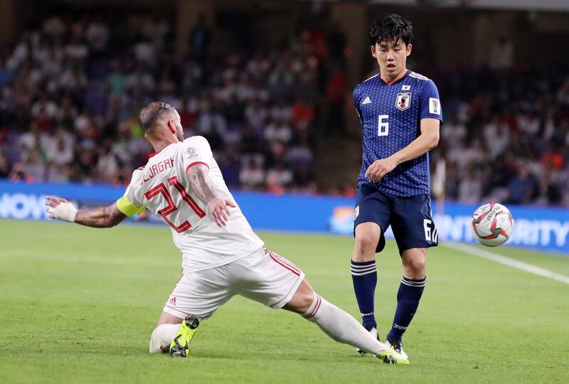 Al Ain, United Arab Emirates - January 28, 2019: Wataru Endo of Japan and Ashkan Dejagah of Iran battle during the semi final of the Asian Cup 2019. Monday, January 28th, 2019 at Hazza Bin Zayed Stadium, Al Ain. Chris Whiteoak/The National