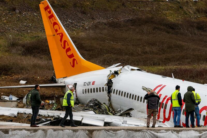 Officials work on the wreckage of a plane operated by Pegasus Airlines after it skidded Wednesday off the runway at Istanbul's Sabiha Gokcen Airport, in Istanbul. AP Photo