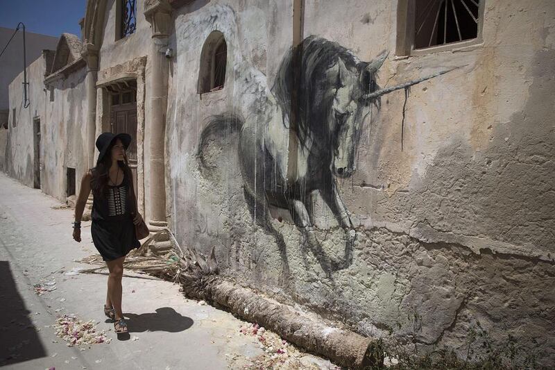 A woman looks at a mural by South African artist Faith 47. Joel Saget / AFP Photo