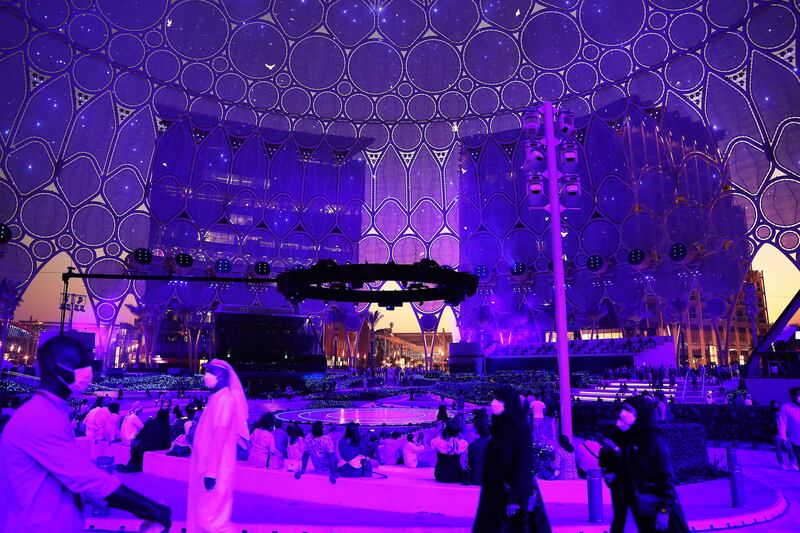 Expo visitors are bathed in coloured light during a multimedia show at Al Wasl Plaza.