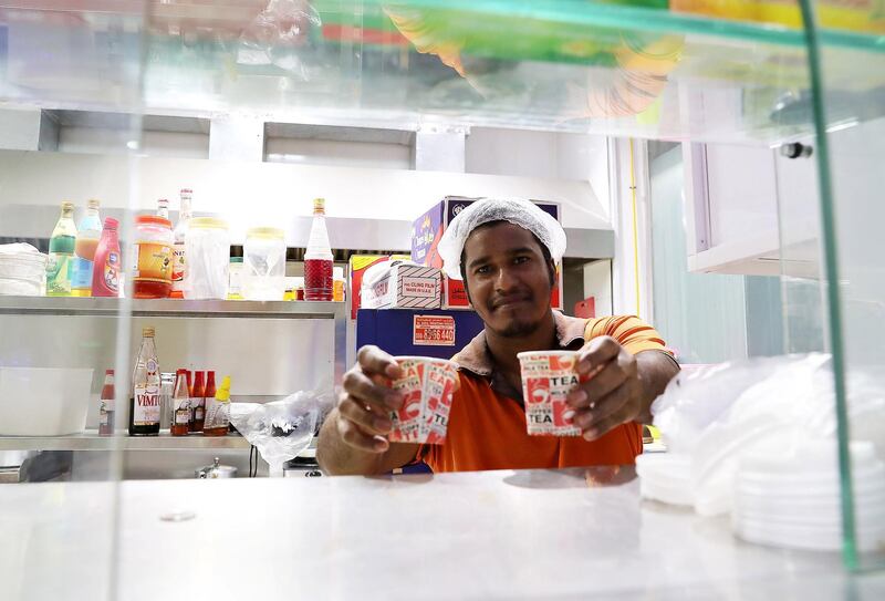 
ABU DHABI , UNITED ARAB EMIRATES , JULY 24 – 2018 :- Anas serving tea to his customers at the King Karak shop in Mussafah area in Abu Dhabi.  ( Pawan Singh / The National )  For News. Story by John
