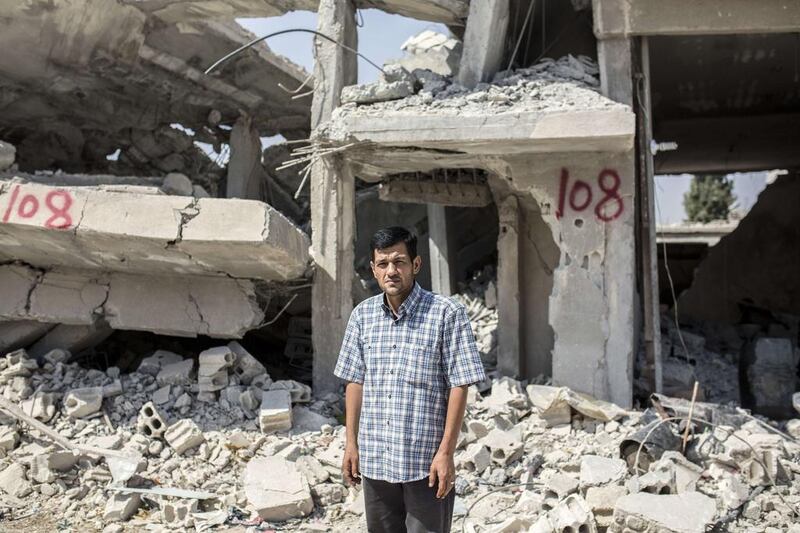 Abdullah Kurdi, whose family drowned off Turkey, stands in front of his neighbour’s house in Kobani, Syria, yesterday. Yasin Akgul / AFP 