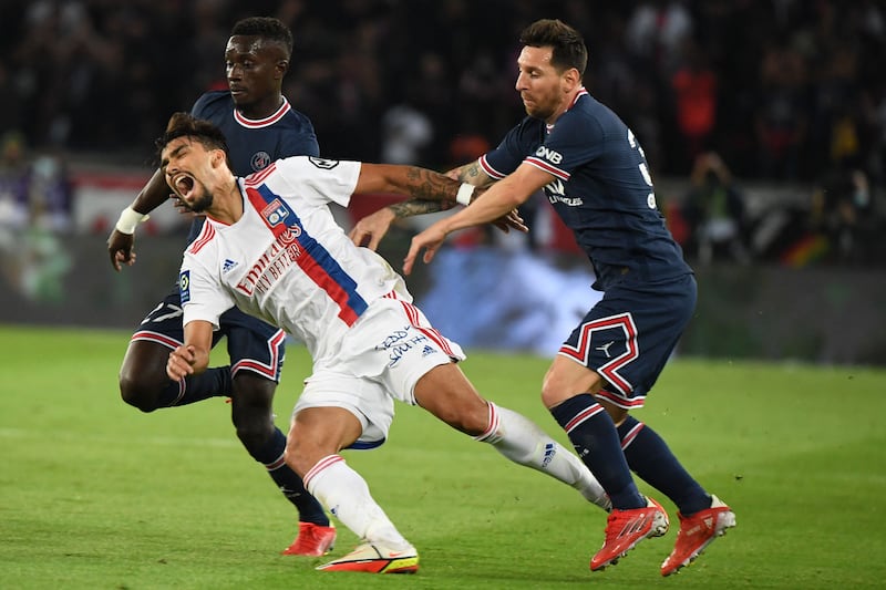 Lyon's Brazilian midfielder Lucas Paqueta is fouled by Paris Saint-Germain's Argentinian forward Lionel Messi during the French Ligue 1 match at The Parc des Princes on September 19, 2021. AFP