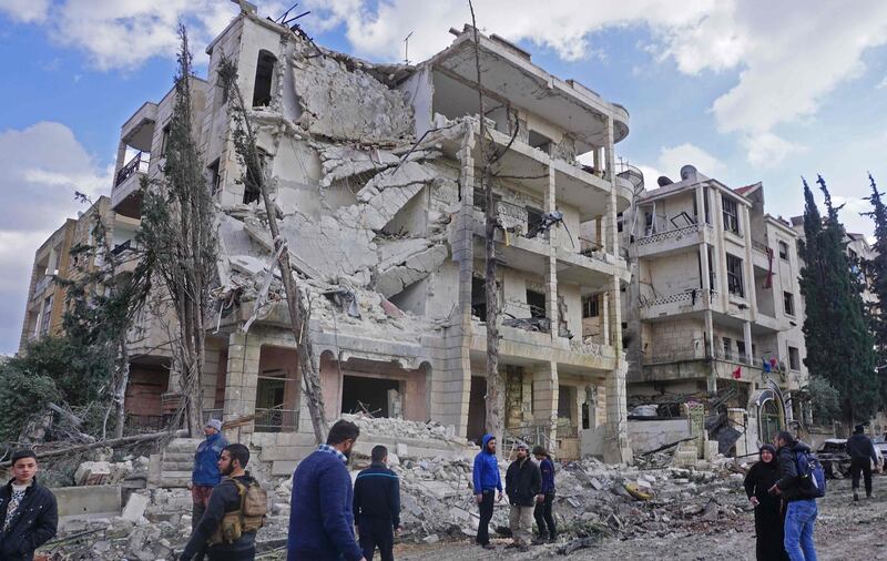 Syrians gather at the scene of a double attack in Syria's northwestern jihadist-held city of Idlib, on February 18, 2019. A twin bomb attack killed more than ten people, including civilians, in Idlib where Syria's former Al-Qaeda affiliate, Hayat Tahrir al-Sham, took administrative control last month, a war monitor said. / AFP / Muhammad HAJ KADOUR
