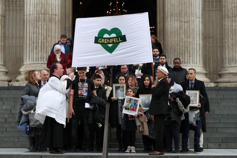 LONDON, ENGLAND - DECEMBER 14: Mourners hold up photogrpahs of victims as they leave the Grenfell Tower National Memorial service at St Paul's cathedral on December 14, 2017 in London, England. The Royal Family and Prime Minister will join survivors of the Grenfell Tower fire at the memorial at St Paul's Cathedral for the six-month anniversary which killed 71 people. About 1,500 people are expected to attend  the multi-faith service. (Photo by Daniel Leavl-Olivas-Pool Getty Images)
