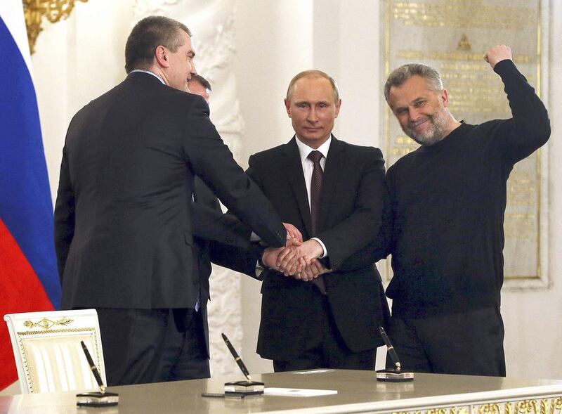 The Russian president Vladimir Putin, second from right, Crimea’s prime minister Sergei Aksyonov, left, Sevastopol mayor Alexei Chaliy, right, and the Crimean parliamentary speaker, Vladimir Konstantinov, shake hands at the Kremlin after the signing of a treaty to make Crimea a part of Russia. Sergei Ilnitsky / Reuters / March 18, 2014