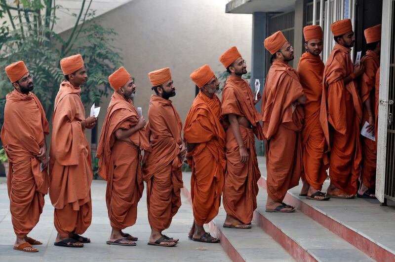 Hindu saints stand in a queue to casts their votes at a polling station during the last phase of Gujarat state assembly election on the outskirts of Ahmedabad. Amit Dave / Reuters