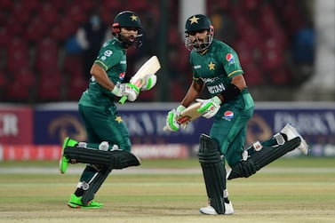 Pakistan's captain Babar Azam (R) and his teammate Mohammad Rizwan run between the wickets during the third Twenty20 international cricket match between Pakistan and West Indies at the National Stadium in Karachi on December 16, 2021.  (Photo by ASIF HASSAN  /  AFP)