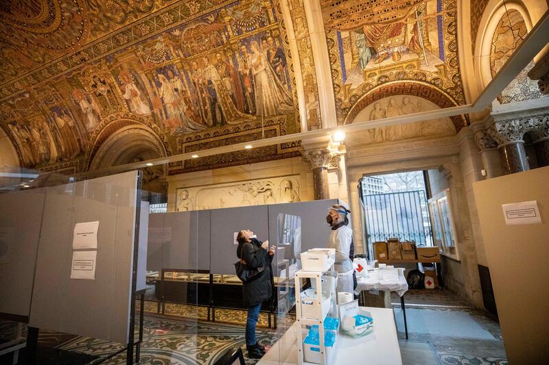 A medical worker helps a woman take a PCR test at a Covid-19 testing station set up in the Kaiser Wilhelm Memorial Church in Berlin, Germany. Getty Images