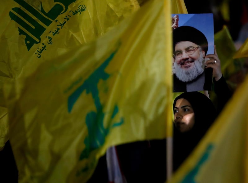 A Hezbollah supporter holds up a portrait of Hezbollah leader Sayyed Hassan Nasrallah, during a rally marking the 12th anniversary of the 2006 Israel-Hezbollah war, in Beirut, Lebanon, Tuesday, Aug. 14, 2018. The leader of Lebanon's militant Hezbollah group says U.S. sanctions against Iran and his group will not have major effects on them. (AP Photo/Hussein Malla)
