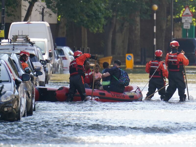 Members of the fire brigade help ferry local residents in Holloway, north London, after a water main burst causing flooding up to 1.2 metres deep. PA