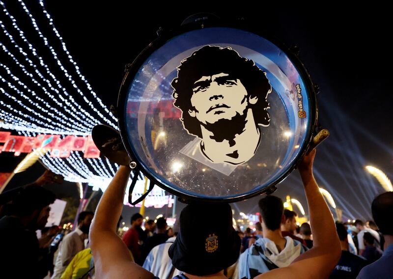 An Argentina fan holds up his drum showing an image of former player Diego Maradona on the Doha Corniche. Friday marked the two-year anniversary of the 1986 World Cup winner's death. Reuters 
