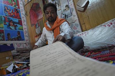 In this picture taken on June 11, 2020, a Hindu priest reads a book containing records of the ancestors of different families at Kusha ghat on the banks of the river Ganges, after the government eased a nationwide lockdown imposed as a preventive measure against the COVID-19 coronavirus at Haridwar in Uttarakhand state. Life is slowly returning to normal among the hallowed temples of Haridwar, one of Hinduism's holiest places, but the Indian pilgrimage town still has a forlorn air as the country emerges from its coronavirus lockdown. - TO GO WITH Virus-health-India-religion-tradition-tourism,SCENE by Bhuvan BAGGA
 / AFP / Money SHARMA / TO GO WITH Virus-health-India-religion-tradition-tourism,SCENE by Bhuvan BAGGA

