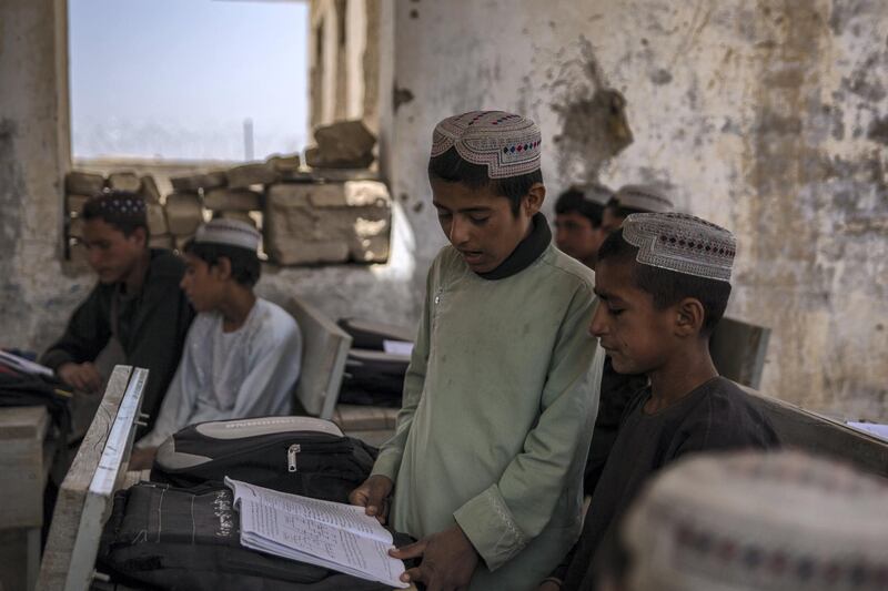 Students sit in their classroom at Assad Suri Primary School in Kandahar's Zhari District. Many of the buildings have been destroyed in airstrikes and by blasts, leaving classrooms exposed and bullet riddled. Part of the school continues to be occupied by the local police. 