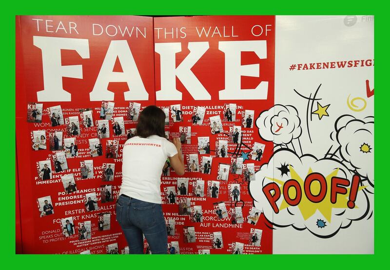 BERLIN, GERMANY - MAY 02:  A stand hostess attaches a photo to a wall themed against Fake News at the annual re:publica conferences on their opening day on May 2, 2018 in Berlin, Germany. Re:publica 18 is holding a series of conferences themed with digital society on topics such as media, entertainment, politics, culture and technology from May 2-4.  (Photo by Sean Gallup/Getty Images) ***BESTPIX***