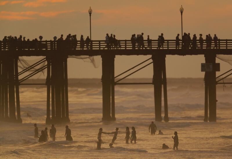 People cool off in the ocean after sunset in Oceanside, California, U.S. July 5, 2018. REUTERS/Mike Blake
