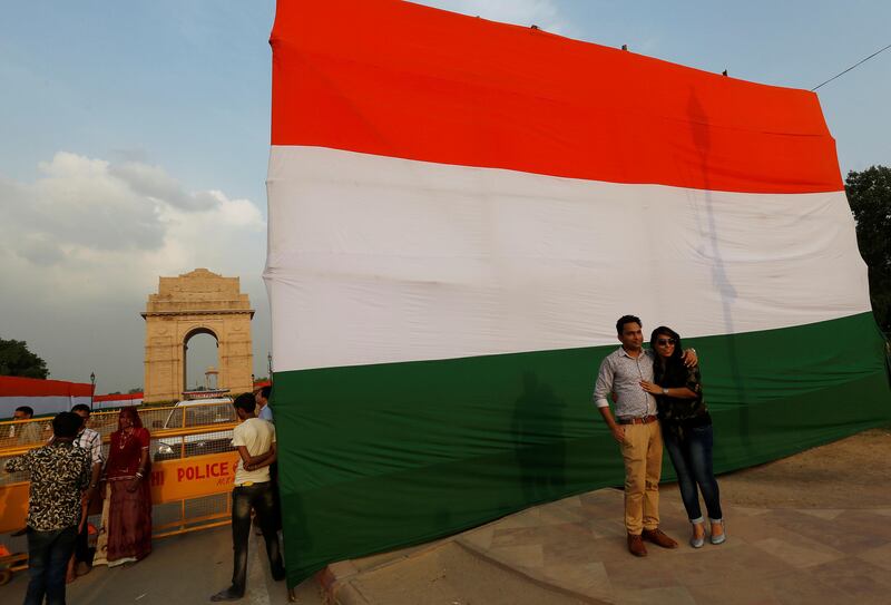 A couple pose in front of a flag in New Delhi. Adnan Abidi / Reuters