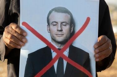 An Israeli Arab protester holds a defaced picture of French President Emmanuel Macron in Hura, a Bedouin village in the Negev desert, Israel. AP Photo